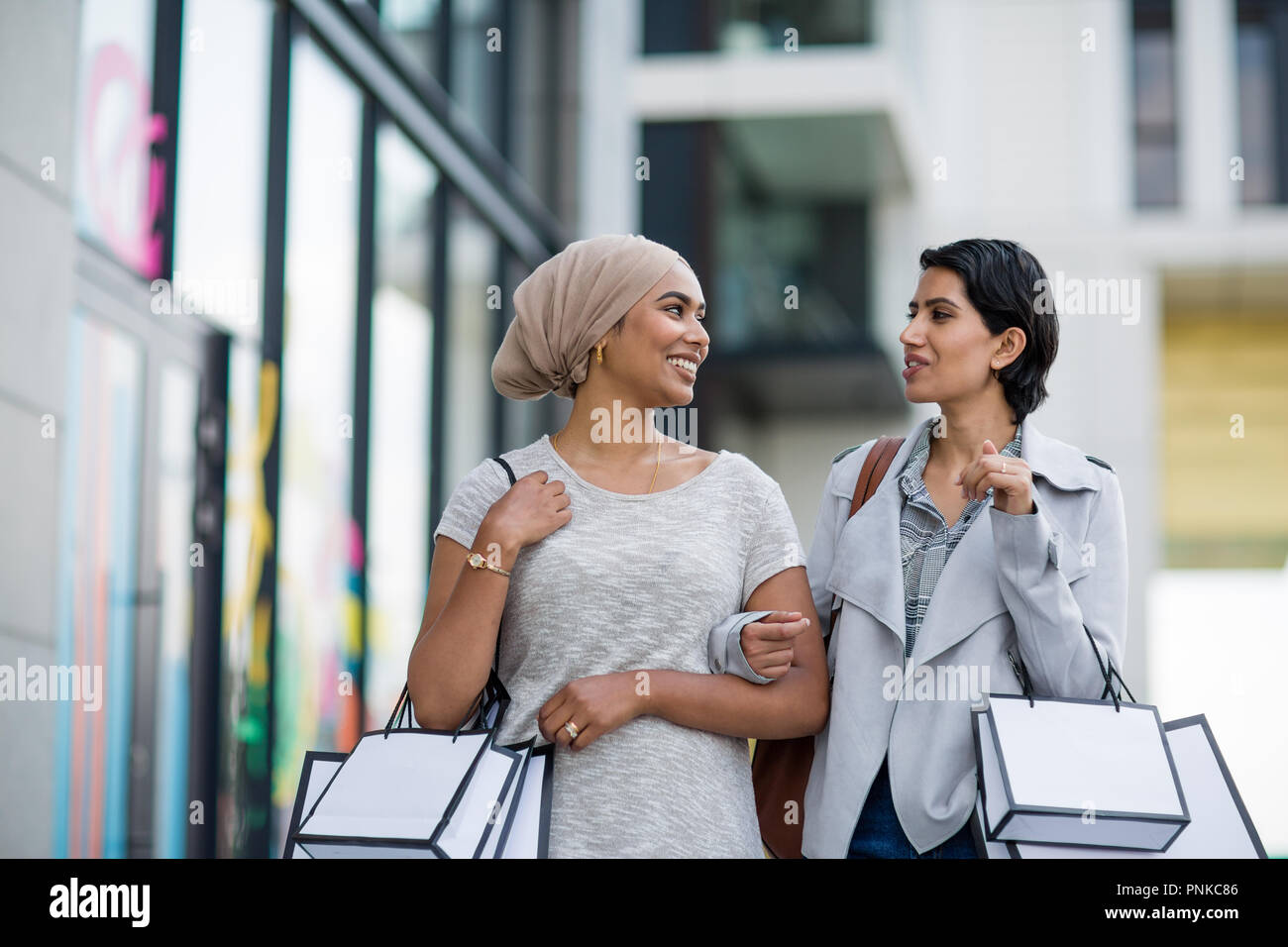 Amis musulmans shopping together outdoors Banque D'Images