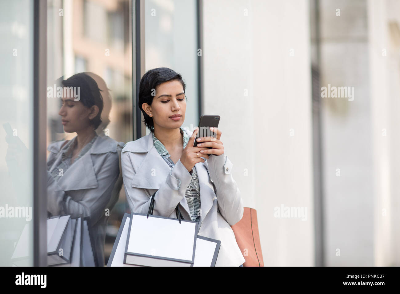 Femme arabe à l'aide d'un smartphone sur un voyage de shopping Banque D'Images