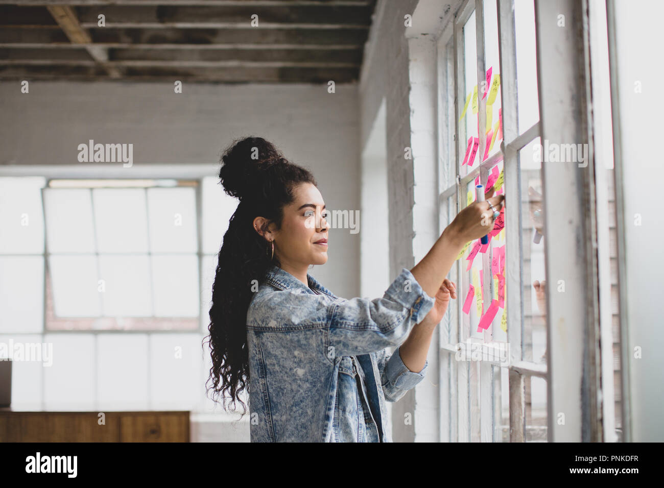 Les jeunes femelles adultes dans un brainstorming creative office avec notes adhésives Banque D'Images Les jeunes femelles adultes dans un brainstorming creative office avec notes adhésives Banque D'Images