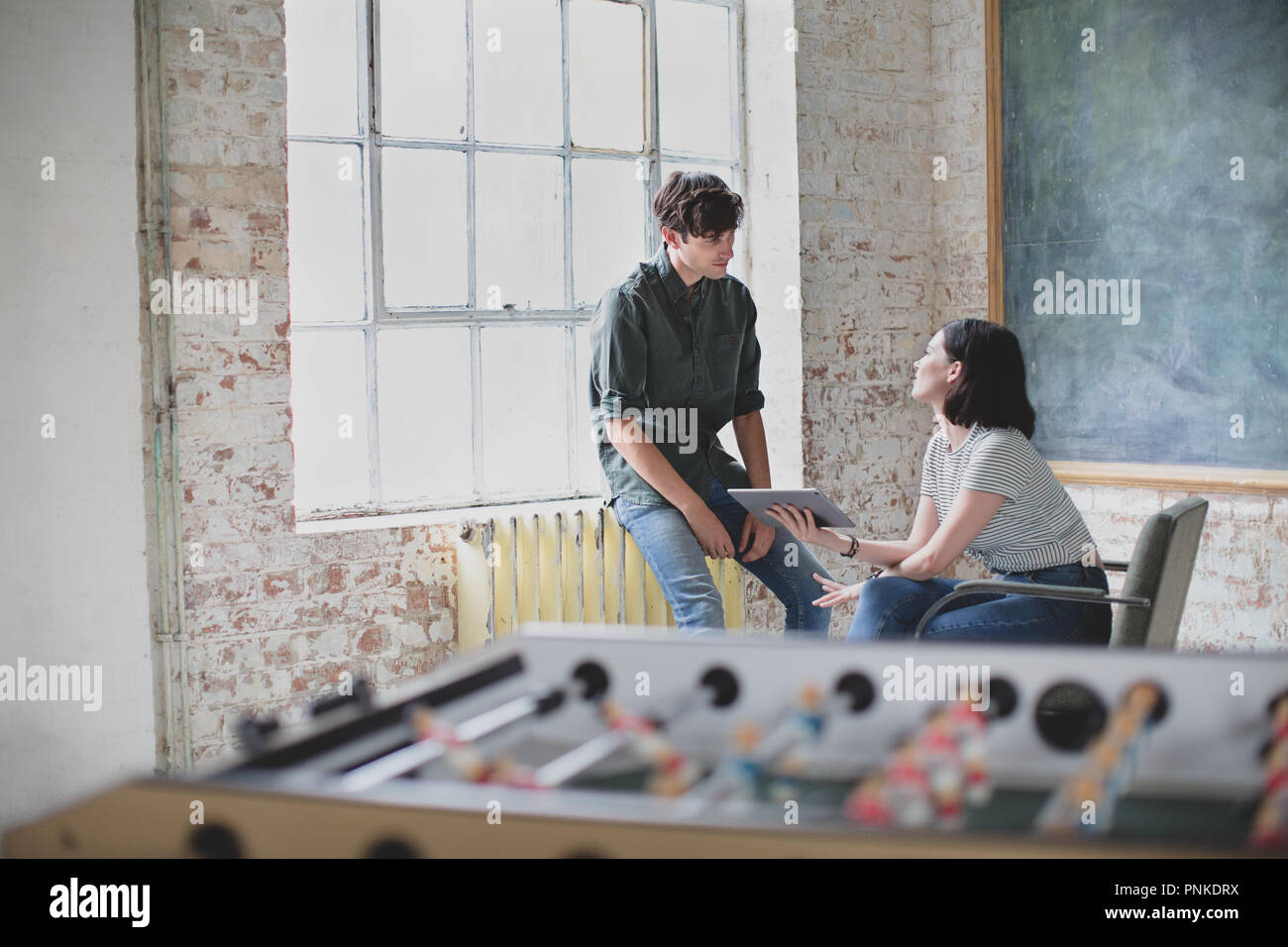 Les jeunes adultes lors d'une rencontre dans un studio de création avec une tablette numérique Banque D'Images Les jeunes adultes lors d'une rencontre dans un studio de création avec une tablette numérique Banque D'Images