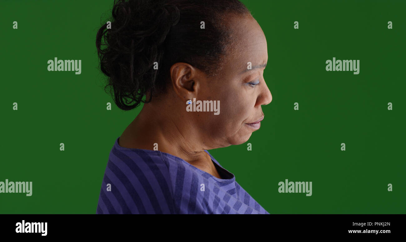 Profil de côté triste vieille femme noire sur un écran vert Banque D'Images