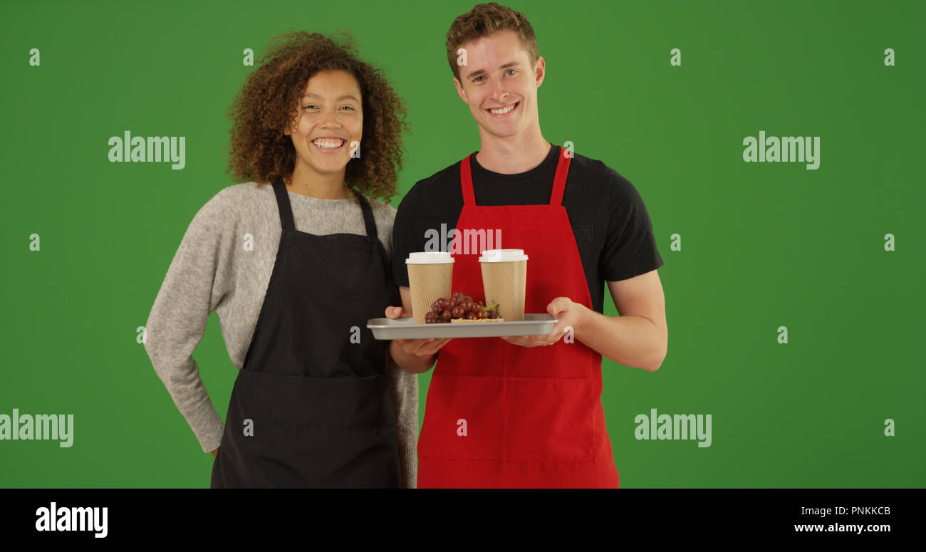 Portrait de deux serveurs avec plateau de nourriture et boissons smiling sur écran vert Banque D'Images