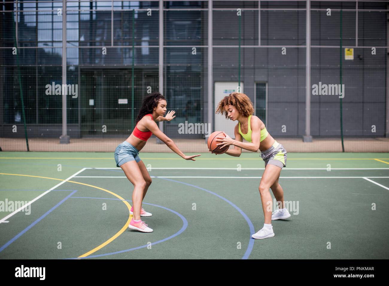 Les jeunes femelles adultes jouant au basket-ball Banque D'Images