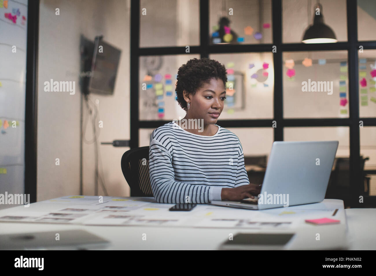 African American female travailler tard dans un bureau Banque D'Images