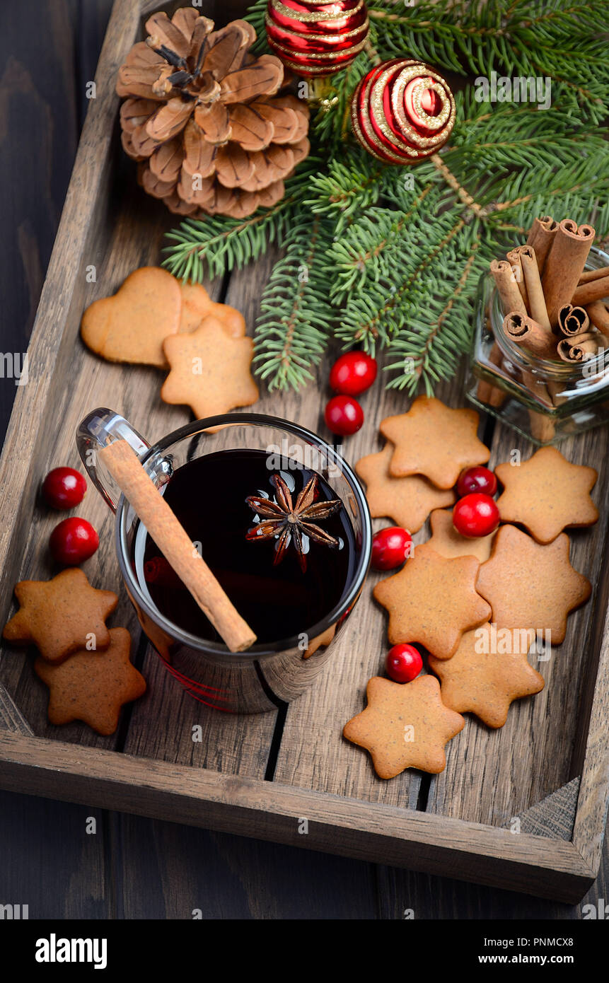 Vin chaud de Noël. Concept de vacances décorée de branches de sapin, Gingerbread Cookies et les canneberges sur un parquet en bois sombre. Banque D'Images