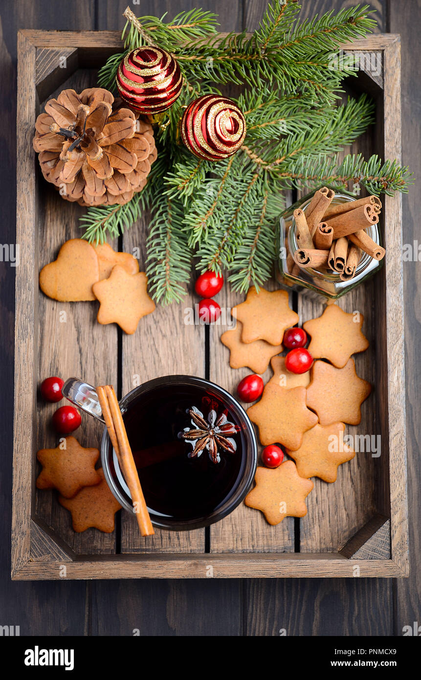 Vin chaud de Noël. Concept de vacances décorée de branches de sapin, Gingerbread Cookies et les canneberges sur un parquet en bois sombre. Banque D'Images