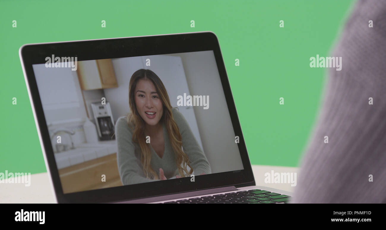 Femme chat vidéo avec asian woman on laptop sur écran vert Banque D'Images