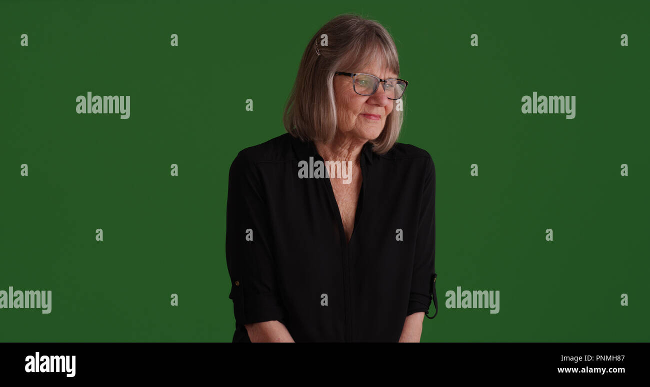 Les personnes âgées déprimées blanc femme contemplant sur écran vert Banque D'Images