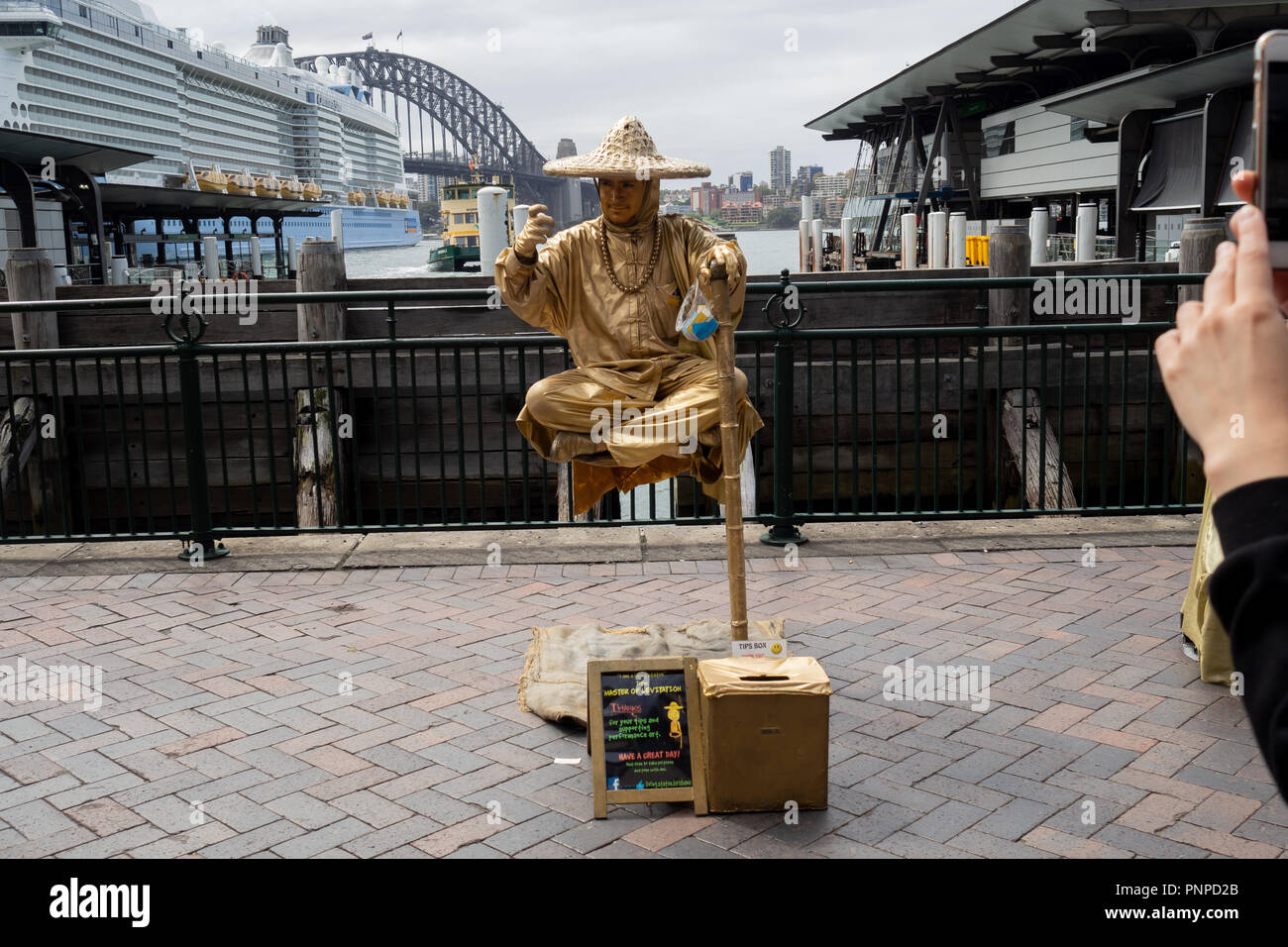 23 mars 2018 : Circular Quay, Sydney, Australie : Street performer en peinture or d'élever sur le sol les jambes croisées Banque D'Images