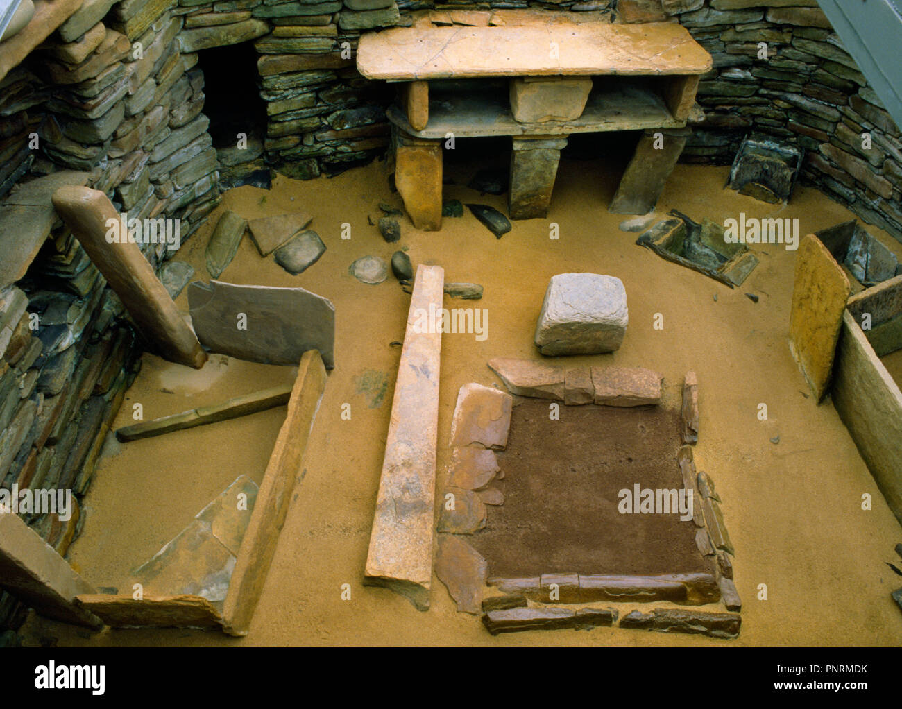 7 chambre à Skara Brae site néolithique, Orkney, Scotland, UK, à la recherche de S au-dessus de l'entrée montrant foyer central en pierre, une commode et deux lits. Banque D'Images