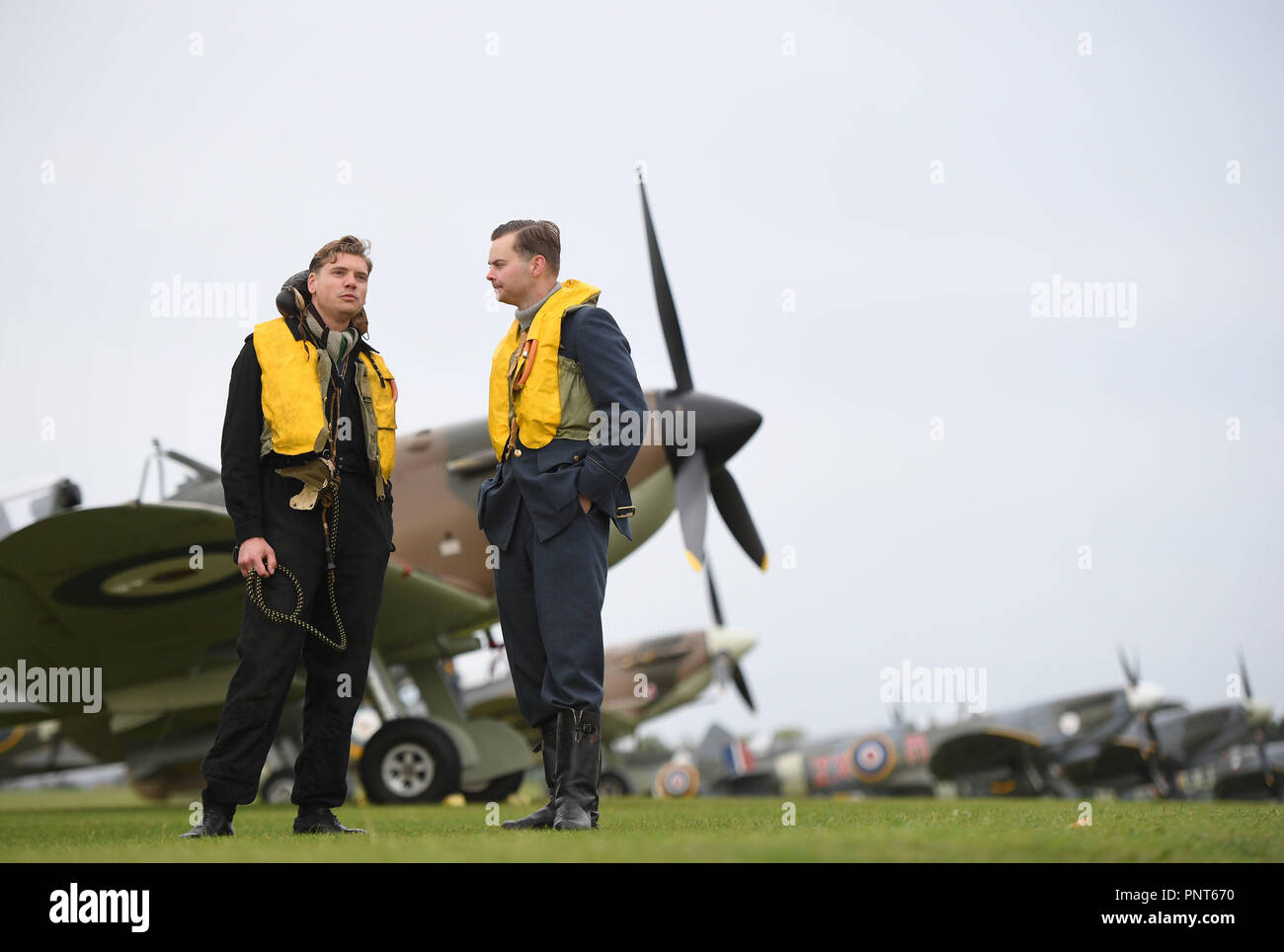 Reconstitution historique membres Jamie Delaney (à gauche) et Gary Lewis de l'esprit de la Grande-Bretagne se tenir sur la ligne de vol en face de Supermarine Spitfire avant la bataille d'Angleterre, à l'Imperial War Museum de Duxford, Cambridgeshire. Banque D'Images
