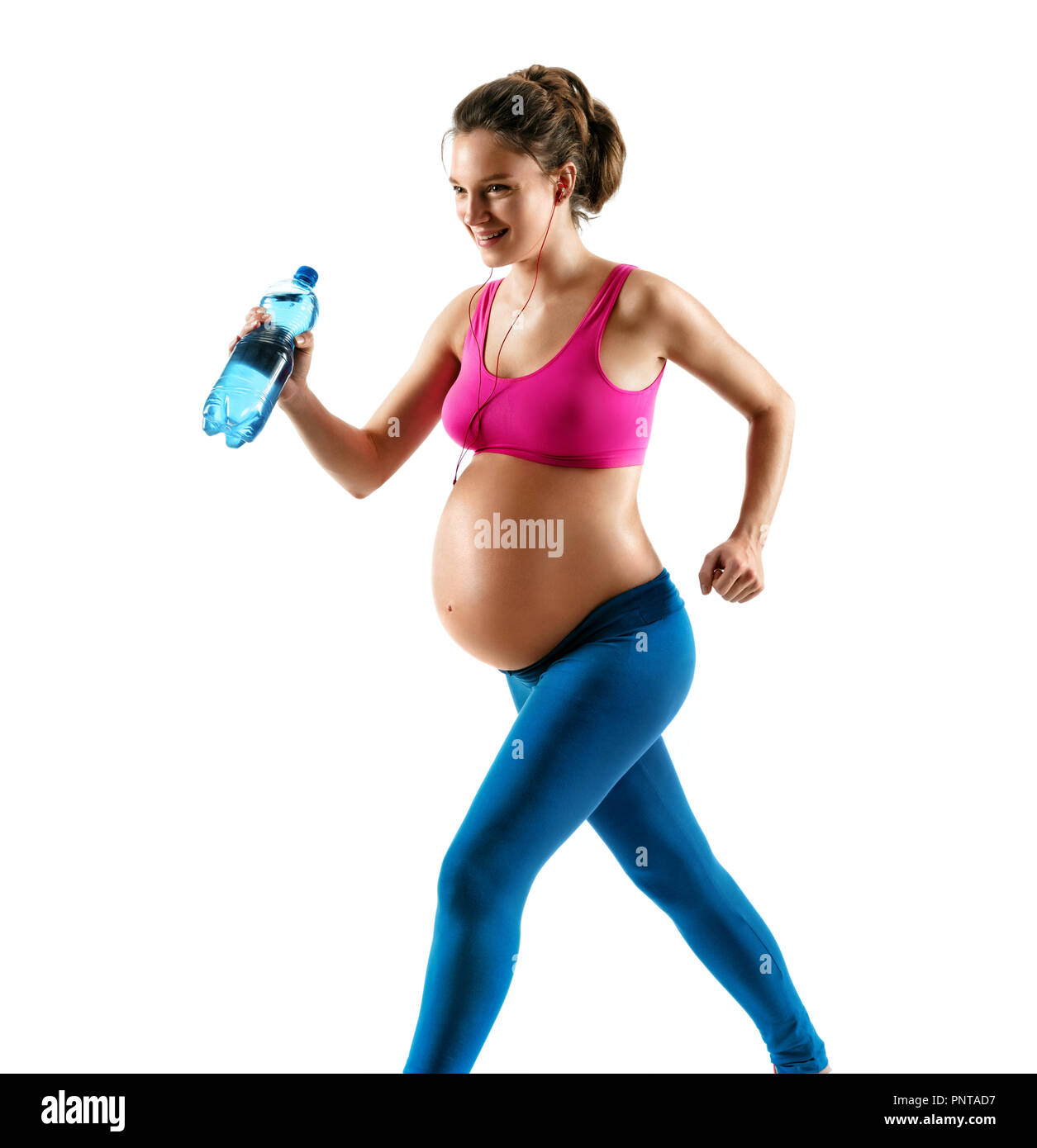 Femme enceinte sportive dans les vêtements de sport le jogging sur fond blanc. Le mouvement dynamique. Concept de vie sain Banque D'Images