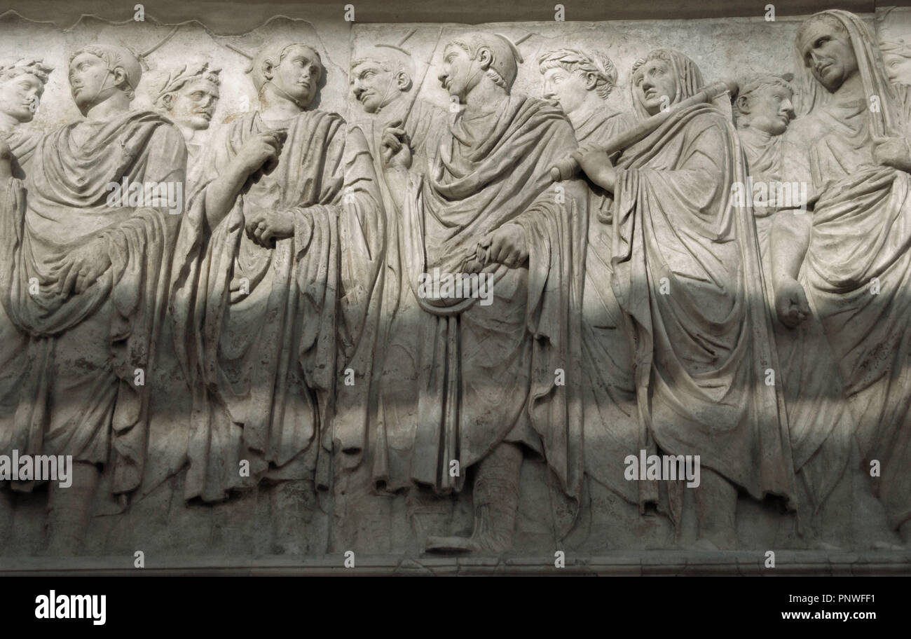 L'Art roman en Italie. Ara Pacis Augustae. Frise de procession. Détail. Le soulagement. Côté sud d'origine. La section centrale. Quatre des figures au centre ont été identifiés comme des flamines, les principaux membres de l'ordre sacerdotal de la religion d'état. Ils utilisent des bouchons en cuir distinctif (galerus), noué sous le menton, avec palmettes devant et derrière les oreilles, avec un point de bois d'olive monté sur un disque (apex) qui dépassent de leur casquette. Ensuite, flaminius licteur, transportant un rituel hache sur son épaule suivi d'Agrippa. En date du 13e siècle avant J.-C.. Musée de l'Ara Pacis. Rome. L'Italie. Banque D'Images