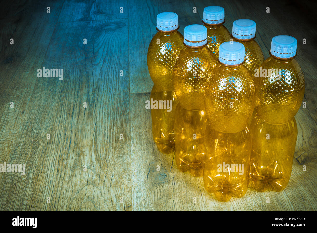 Les bouteilles en PET vides sur fond de bois. La séparation écologique des ordures ménagères. Orange utilisé les paquets avec des moutons blancs sur le sol. Le tri des déchets en plastique. Banque D'Images