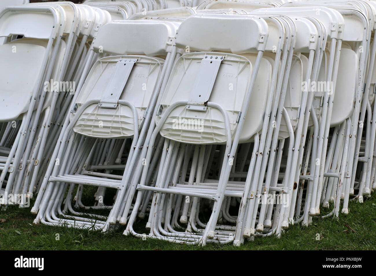 Les chaises blanches sont empilées avant le mariage. Banque D'Images