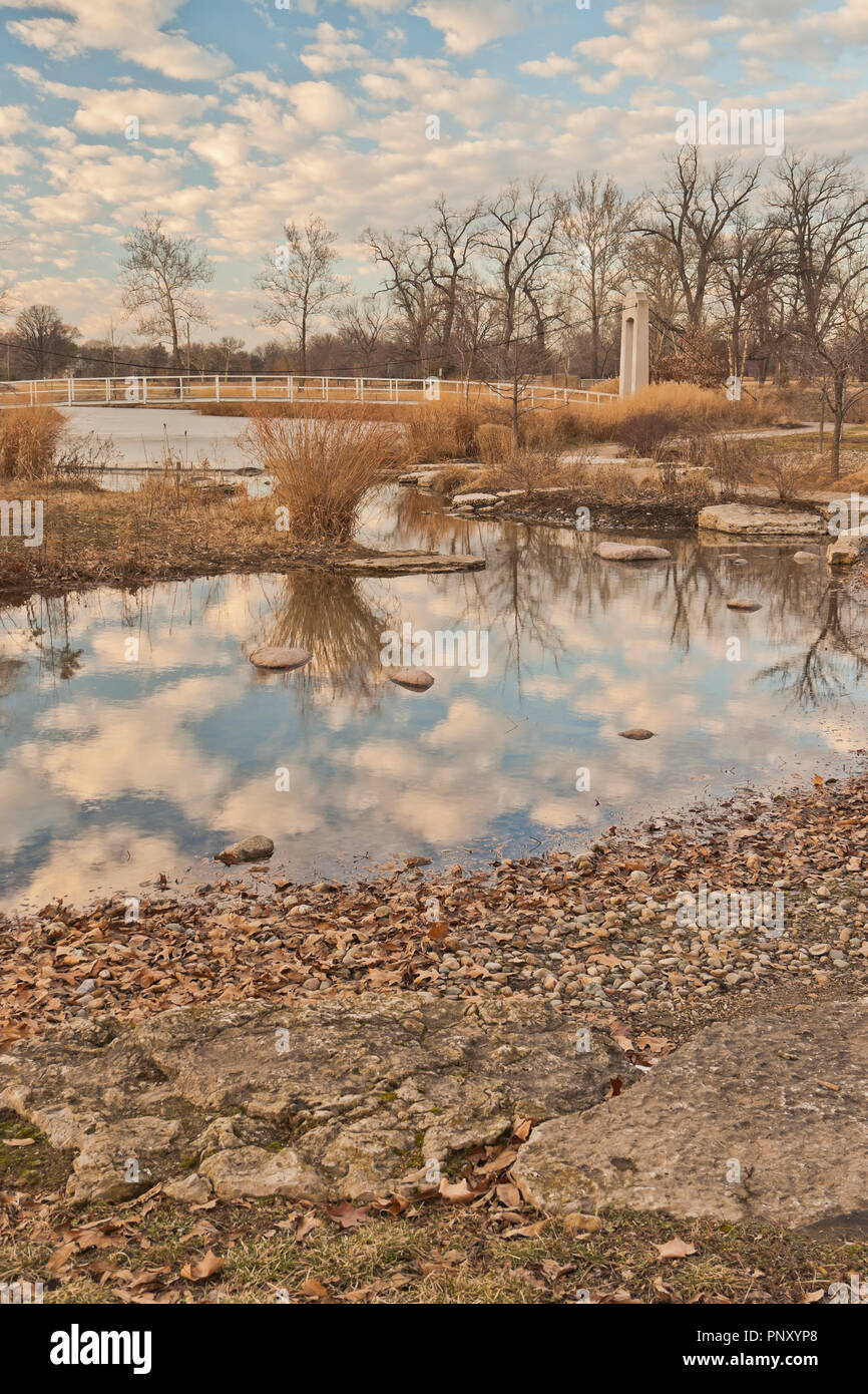 Pont suspendu pour piétons par les rapides à St Louis Forest Park sous un ciel maquereau babeurre reflète dans l'eau sur une fin d'après-midi d'hiver. Banque D'Images Pont suspendu pour piétons par les rapides à St Louis Forest Park sous un ciel maquereau babeurre reflète dans l'eau sur une fin d'après-midi d'hiver. Banque D'Images