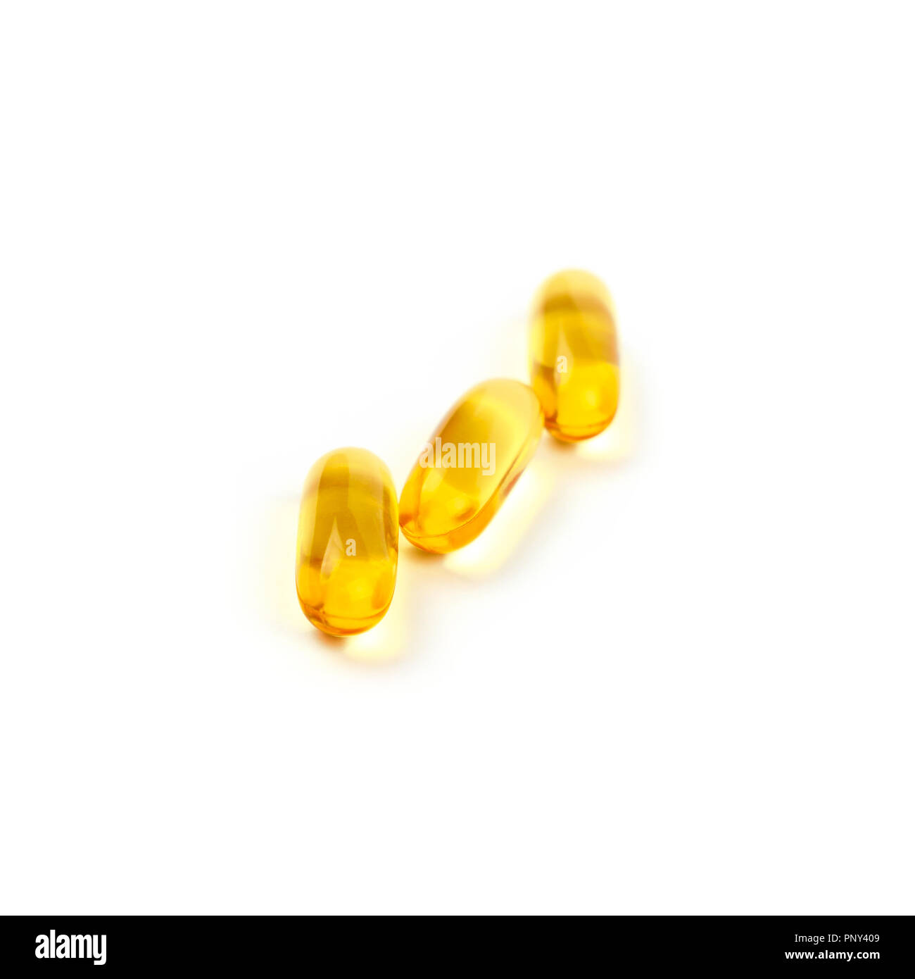 Close up jaune trois vitamines et Omega 3 huiles de poisson essentiel cap gel comprimés isolé sur fond blanc, high angle view Banque D'Images