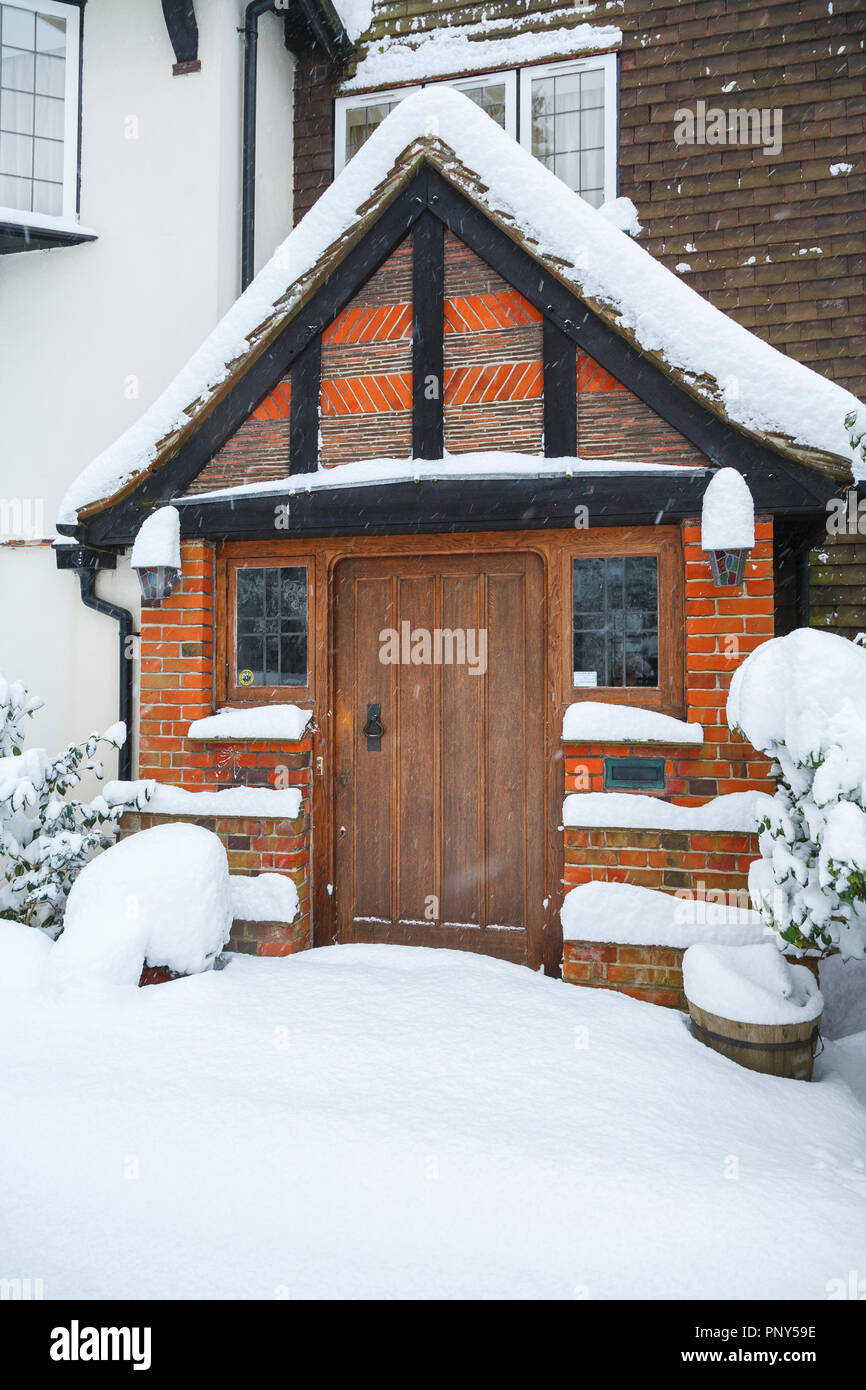 Meubles en chêne porte avant et porche d'une grande maison avec la chasse-neige non perturbées lors de fortes chutes de neige en hiver, Woking, Surrey, Angleterre du Sud-Est, Royaume-Uni Banque D'Images