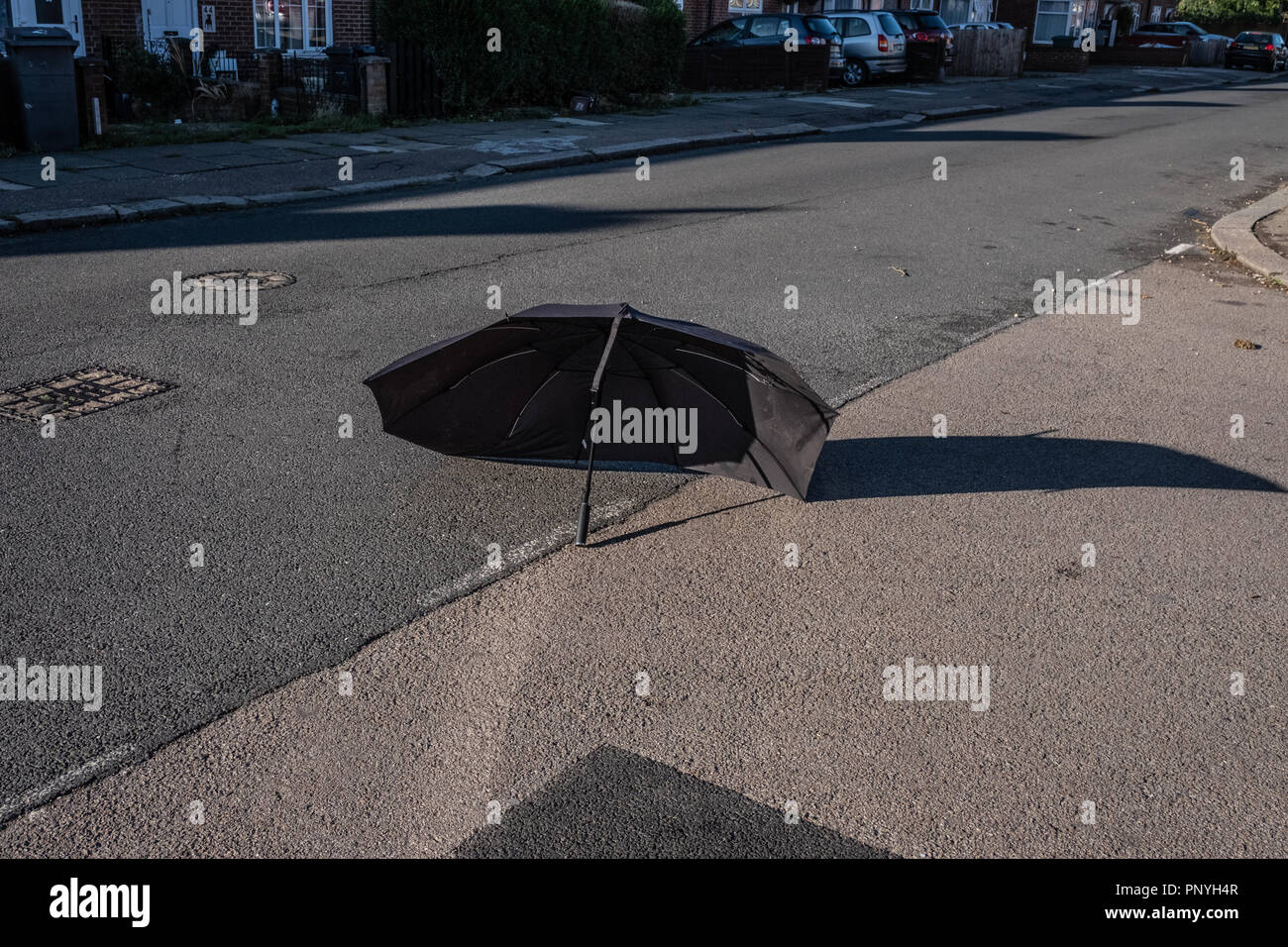 A broken umbrella réside dans la route Banque D'Images