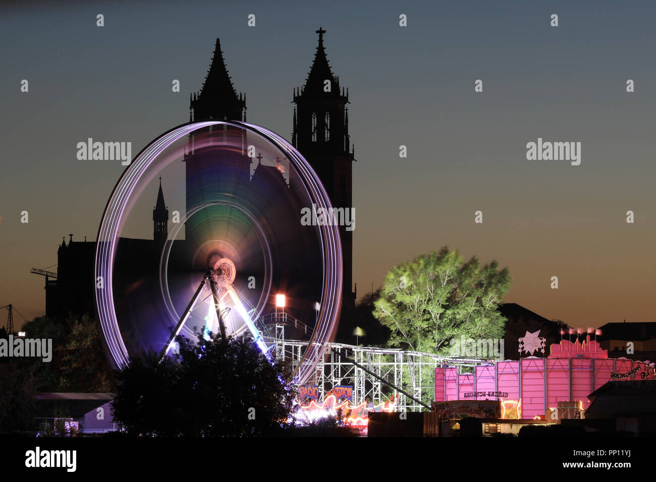 21 septembre 2018, la Saxe-Anhalt, Magdeburg : une grande roue brille en face de la silhouette de la cathédrale 'Saint Joseph et Saint Maurice' à Magdeburg Magdeburg à la 108e Foire d'automne. Jusqu'à 14.10.2018 Les visiteurs peuvent visiter le mile avec manèges et stands sur la petite ville de mars de chaque jour. Photo : Peter Gercke/dpa-Zentralbild/ZB Banque D'Images