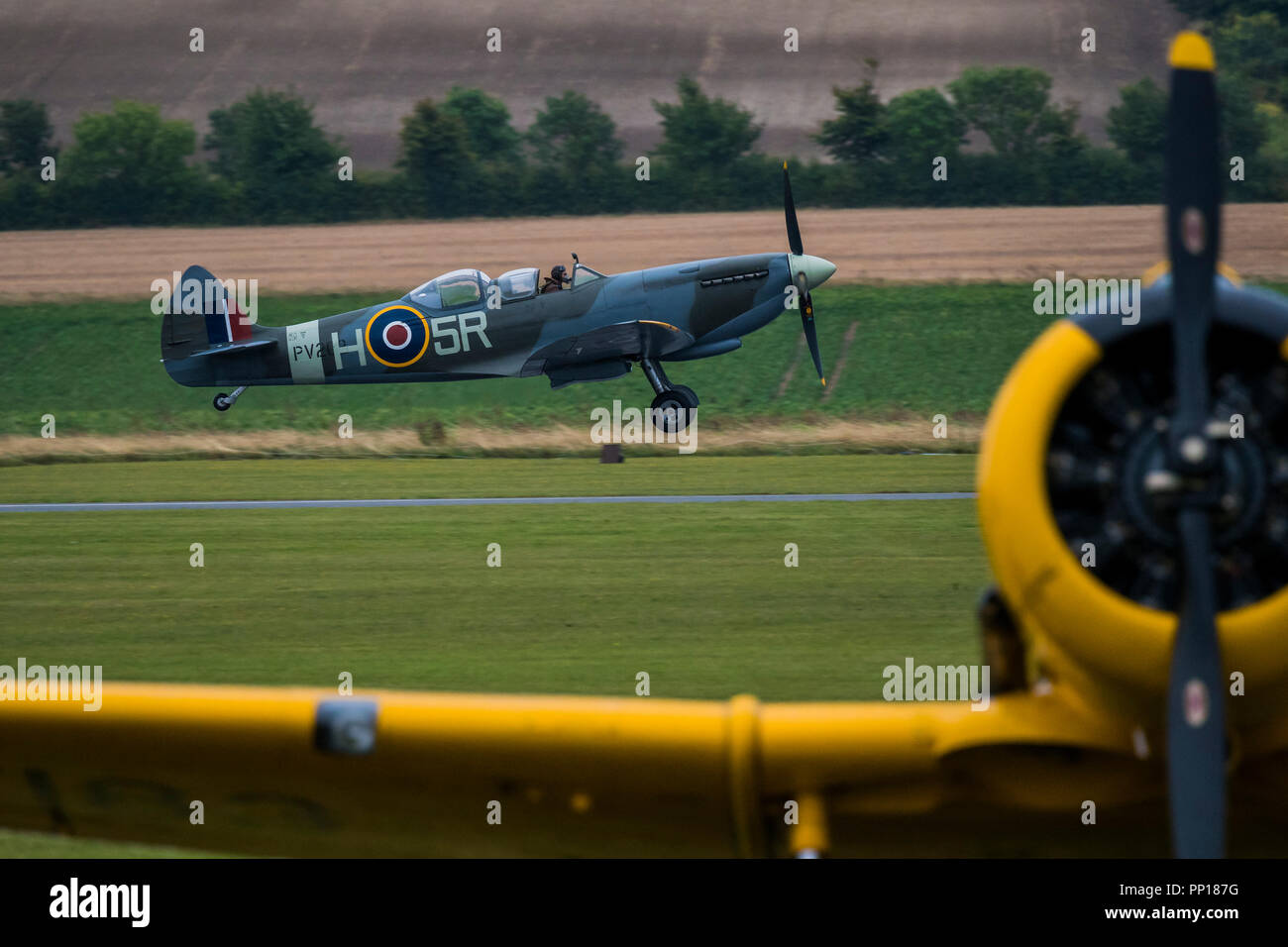 Duxford, UK. 22 Sep, 2018. Spitfire 18 décollage, derrière d'autres avions classiques telles que Harvard, jaune ce de la piste en herbe pour le défilé aérien final - La bataille d'Angleterre de Duxford Air Show est un finale pour le centenaire de la Royal Air Force (RAF) à la célébration de 100 ans d'histoire de la RAF et une vision de la capacité d'avenir. Crédit : Guy Bell/Alamy Live News Banque D'Images