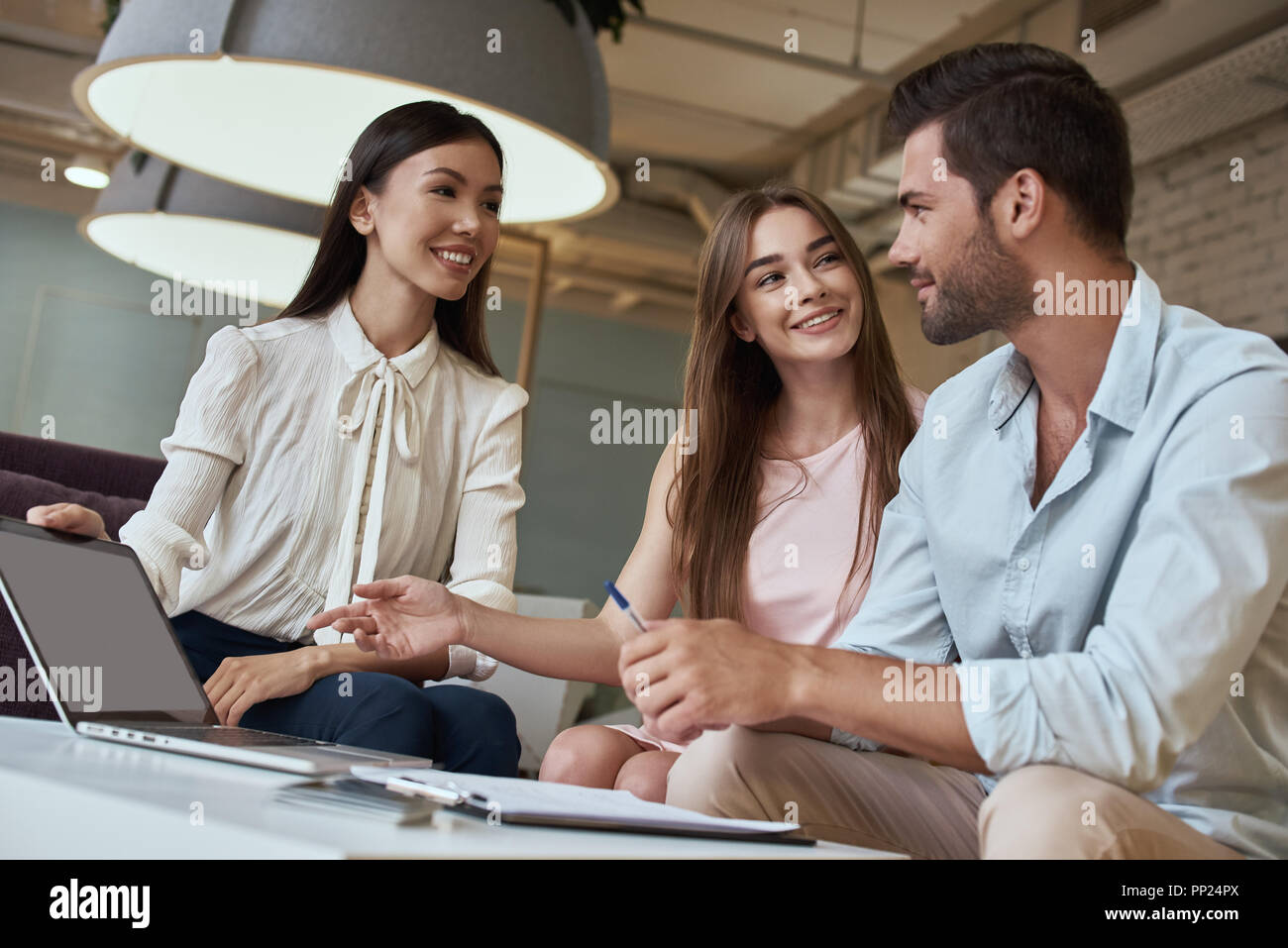 Jeune couple dans une agence de voyages la communication avec un agent de voyage Voyager destination tour concept Banque D'Images