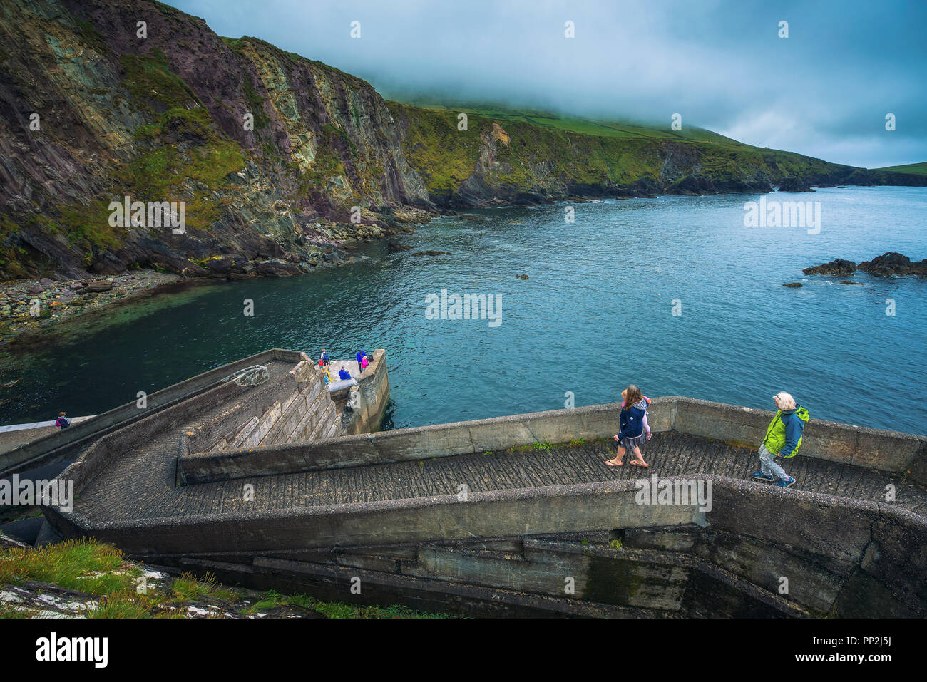 Dunquin, Irlande - Août 3, 2018 : les gens à pied jusqu'à la jetée de Dunquin situé sur la côte ouest de la péninsule de Dingle Banque D'Images