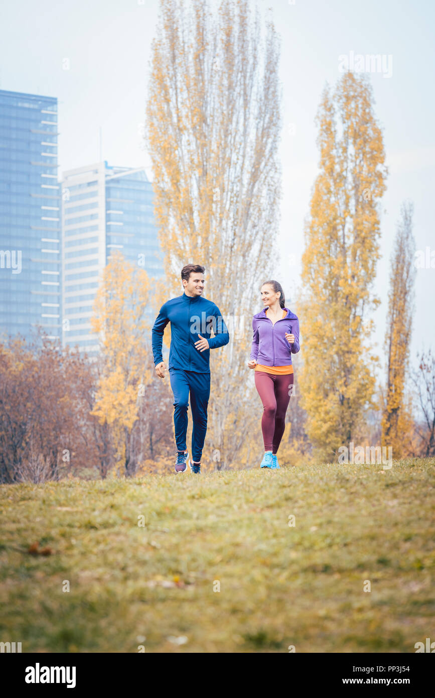Jogging urbain - couple fonctionnant en ville d'automne Banque D'Images
