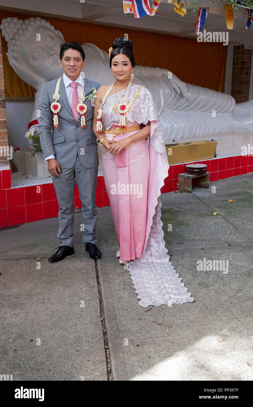 Portrait, en face d'une statue de Buddah de mariée Thaï & son fiancé de l'Amérique du Sud juste après leur mariage bouddhiste à Elmhurst, Queens, New York. Banque D'Images