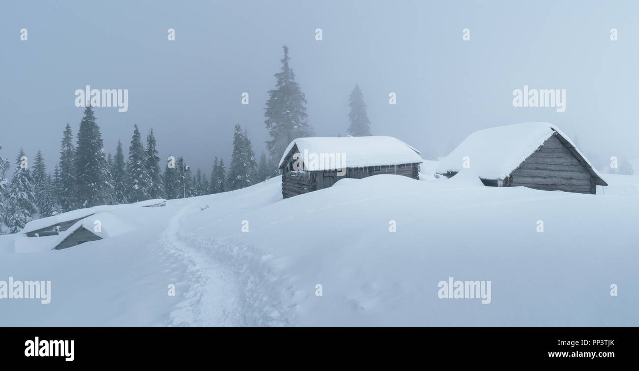 Paysage d'hiver fantastique avec maison en bois dans les montagnes enneigées. Concept de vacances de Noël. La montagne des Carpates, l'Ukraine, l'Europe Banque D'Images