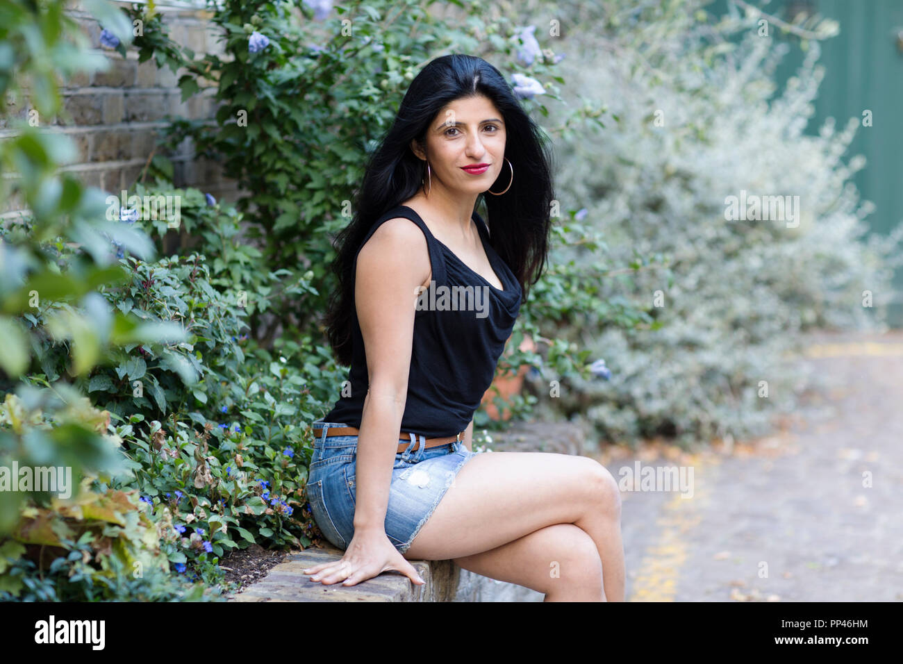 Belle femme indienne assis sur un mur Banque D'Images
