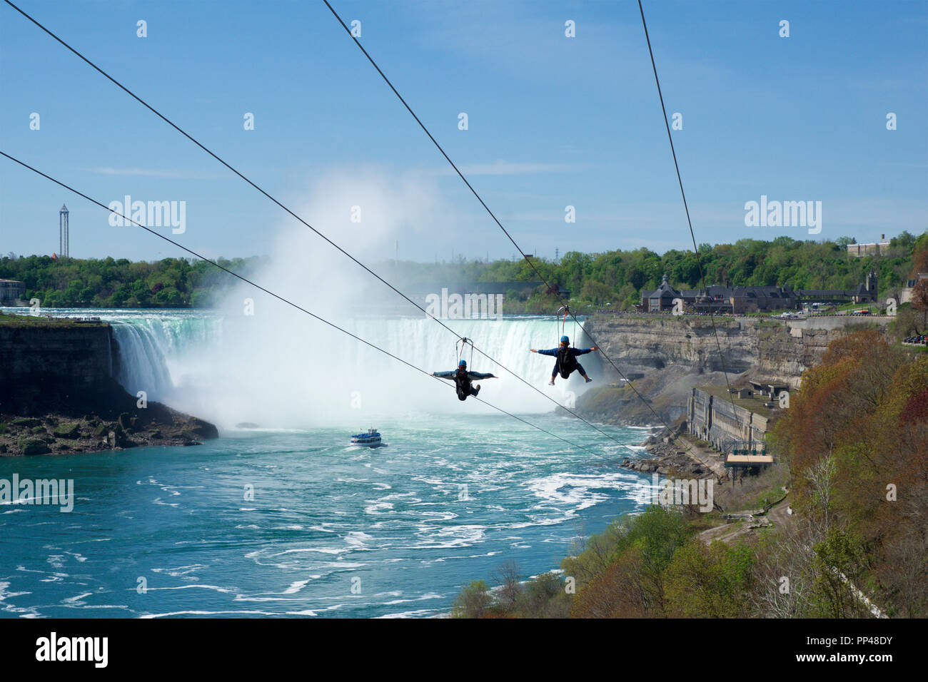 NIAGARA FALLS, ONTARIO, CANADA - 21 MAI 2018 : Deux personnes prenant en tyrolienne à Niagara Falls en été avec des chutes Niagara en arrière-plan Banque D'Images