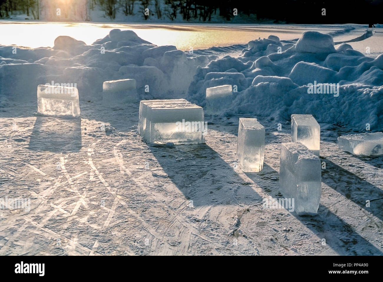 Gros cubes de glace sur un lac glacé avec de la neige et du soleil autour. Banque D'Images