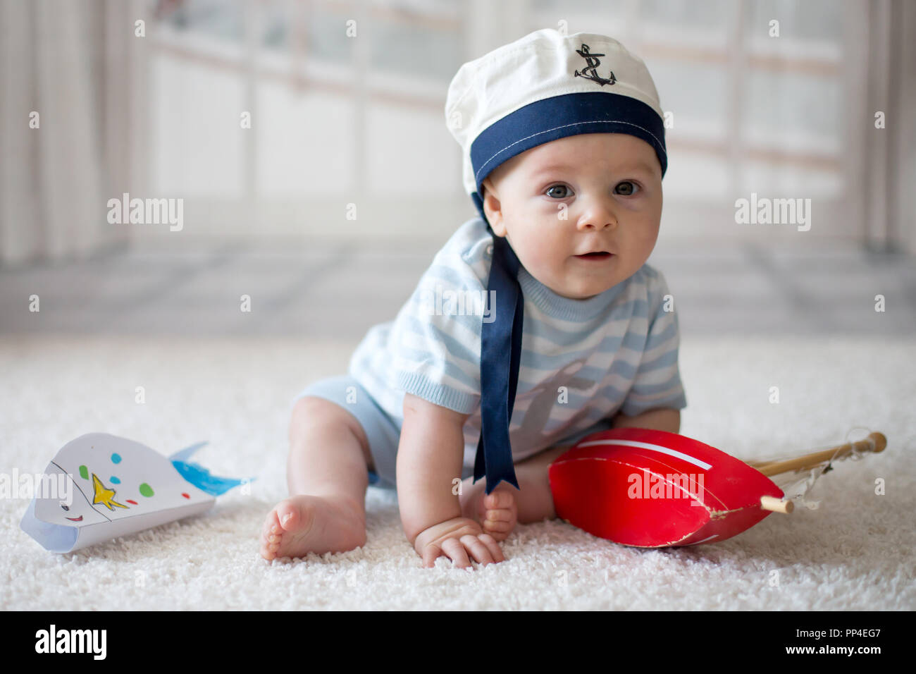 Petit bébé garçon, jouant avec petit bateau et peu de poisson à la maison,  ayant sailor hat Photo Stock - Alamy