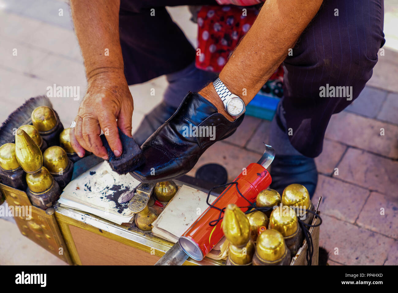 Gros plan du service de cireur dans la rue sur des chaussures en cuir noir Banque D'Images