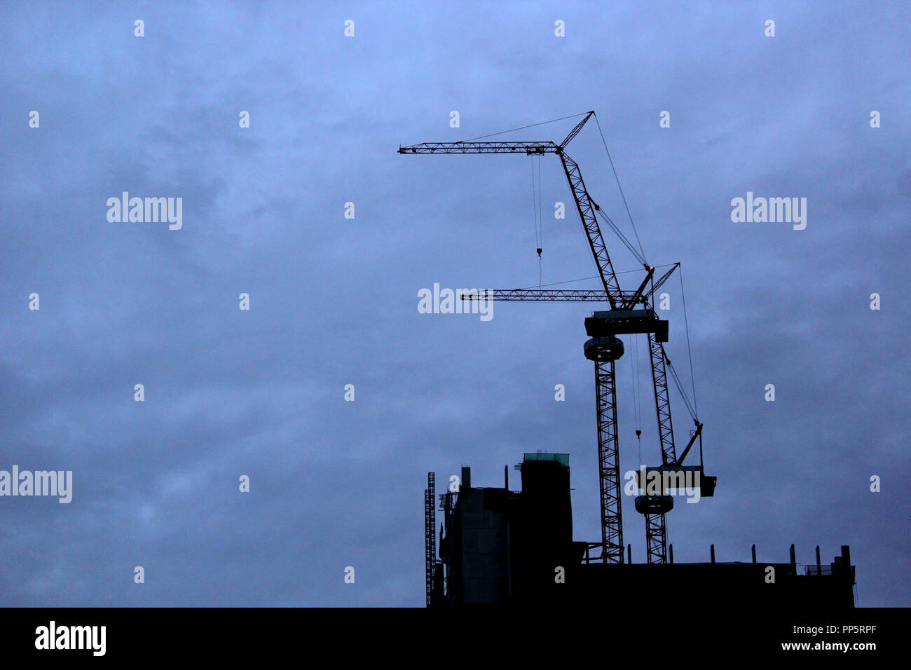 Silhouette de chantier et de grues avec fond de ciel bleu Banque D'Images