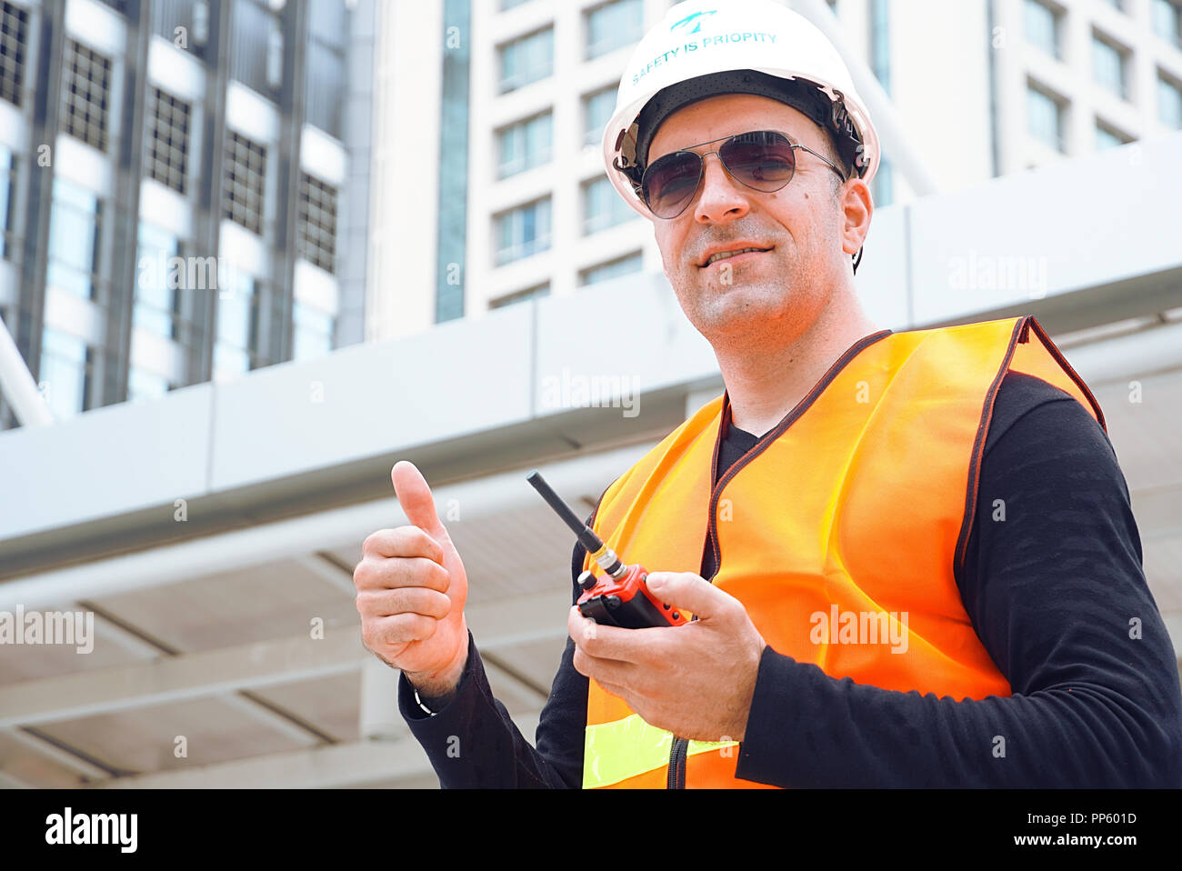 Usure ingénieur casque de sécurité et utilisation de la communication pour le contrôle de la tâche de travail at construction site Banque D'Images