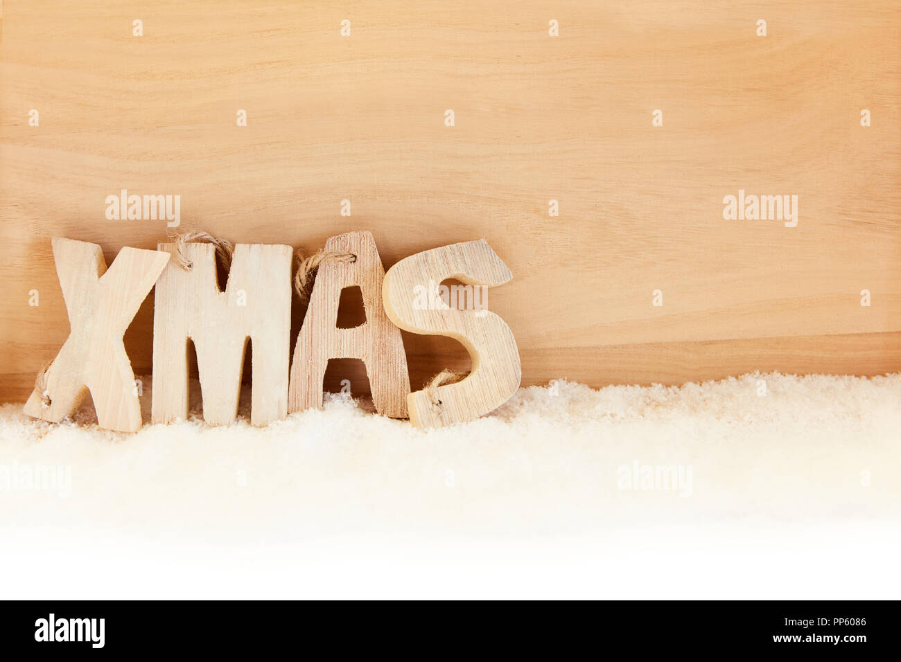 Texte des lettres de Noël pour Noël sur la neige en face d'un fond en bois Banque D'Images Texte des lettres de Noël pour Noël sur la neige en face d'un fond en bois Banque D'Images