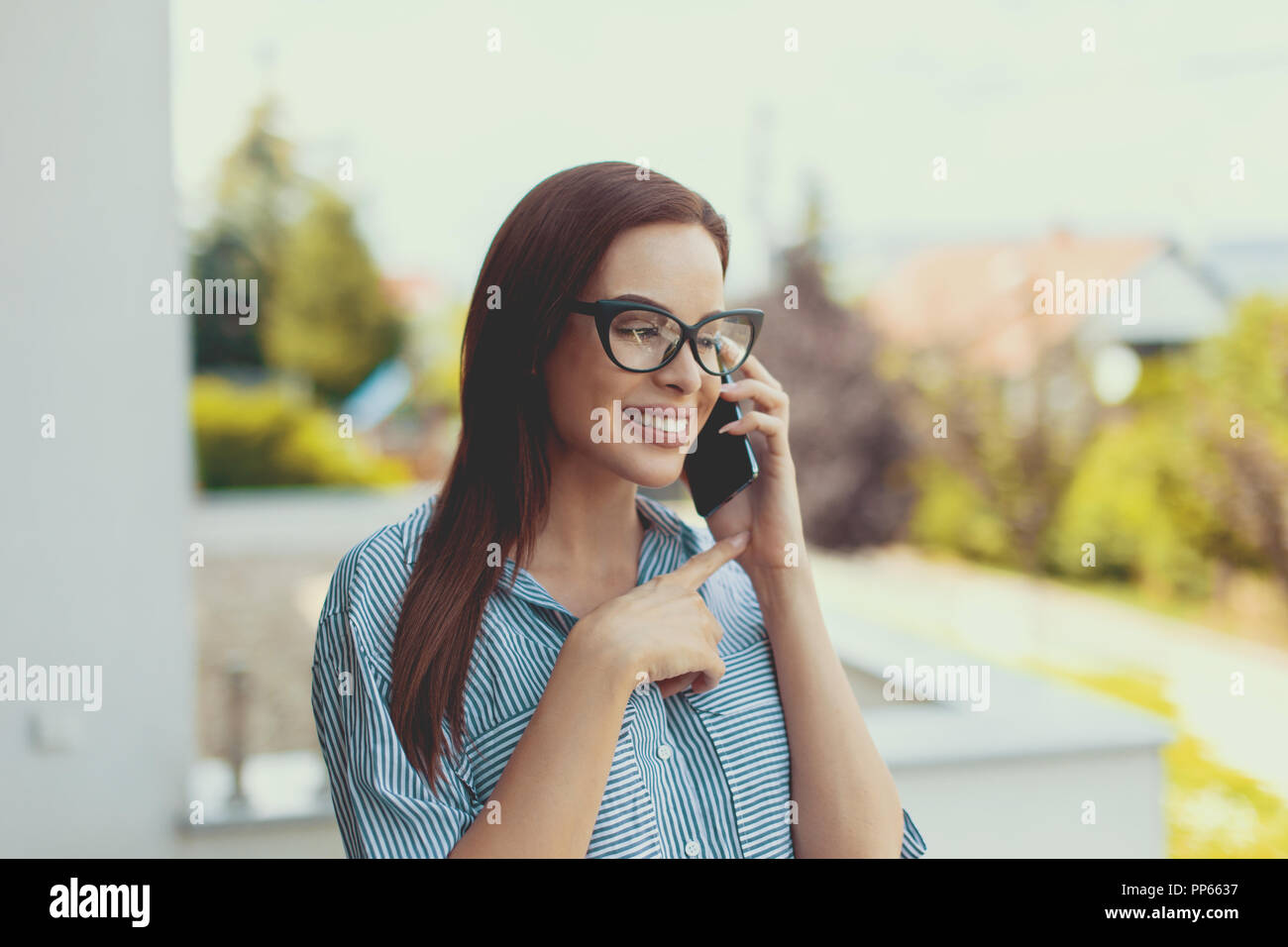 Les jeunes de l'agent immobilier avec appel confiant sourire à pleines dents négocier sur les prix à l'extérieur Banque D'Images