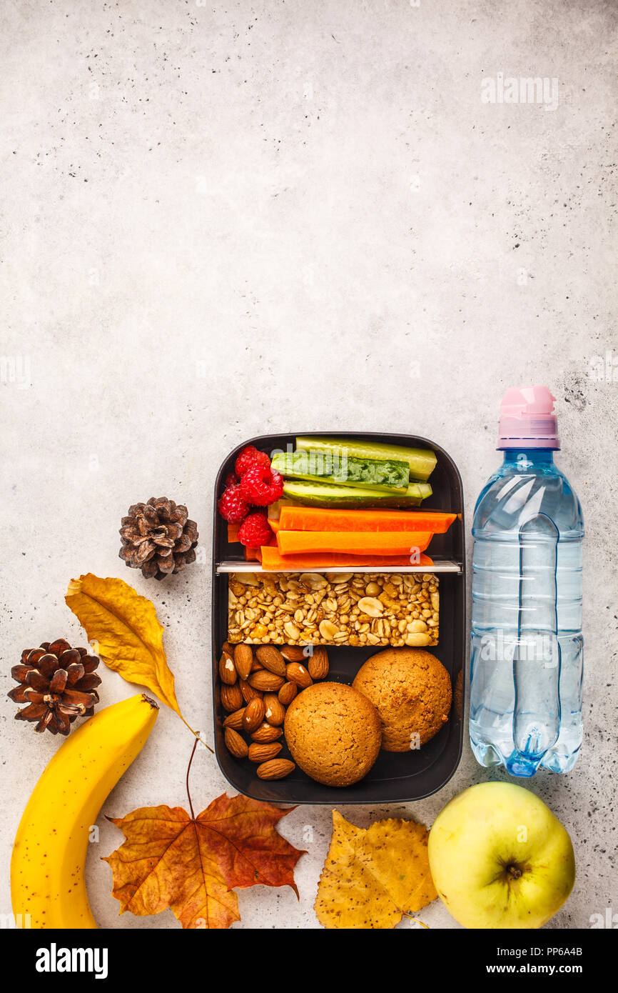 Préparation des repas sains avec conteneurs barre de céréales, fruits, légumes et des collations. La nourriture à emporter sur fond blanc, copie de l'espace, vue d'en haut. Banque D'Images