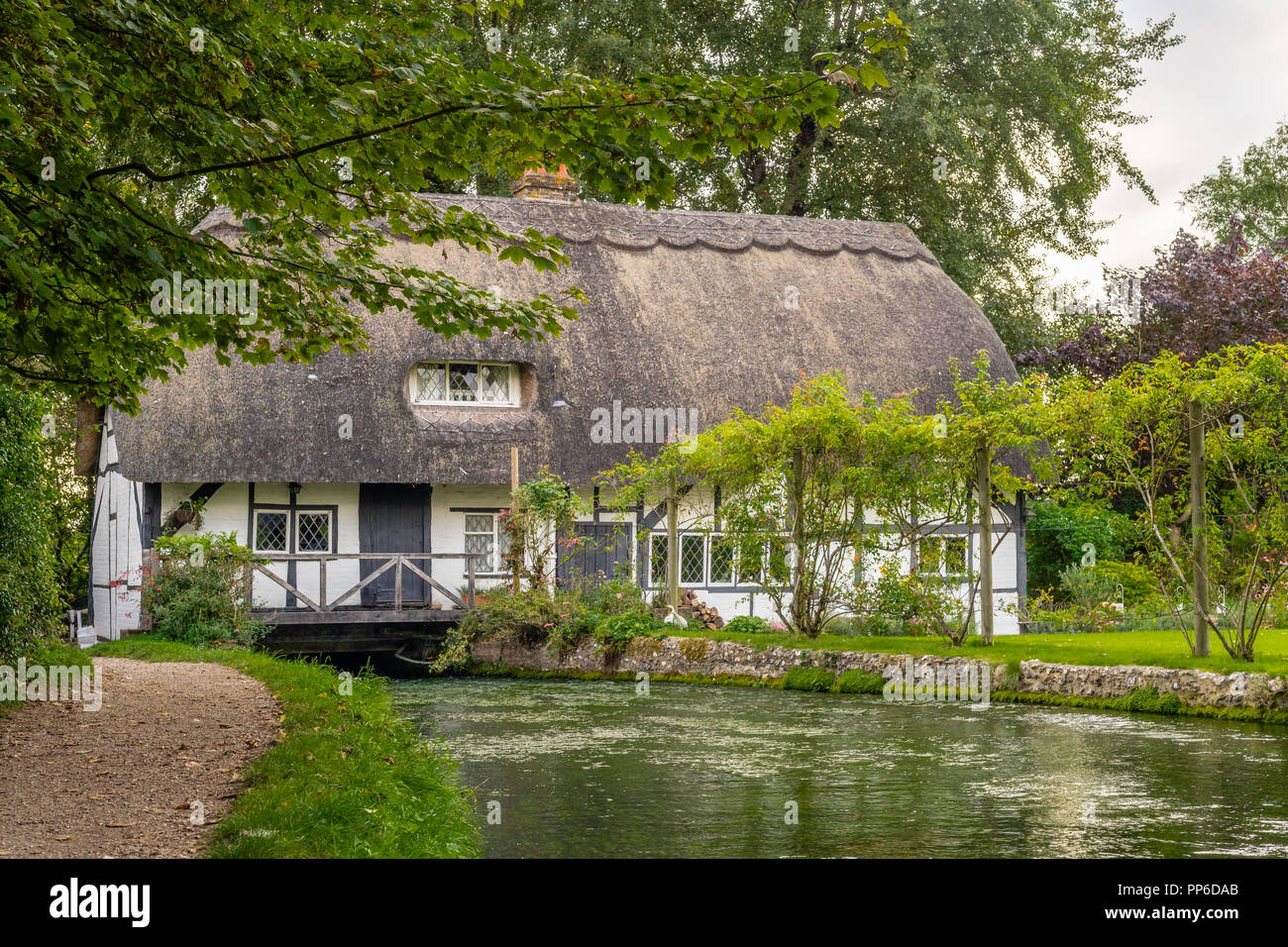 Le Fulling Mill, un cottage traditionnel en toit de chaume, le long de la rivière à New Alresford pendant l'été 2018, Hampshire, Angleterre, Royaume-Uni Banque D'Images