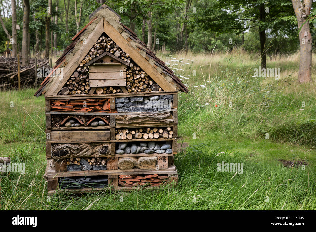 Gros bug maison de plusieurs couches de différents matériaux dans un jardin. Banque D'Images