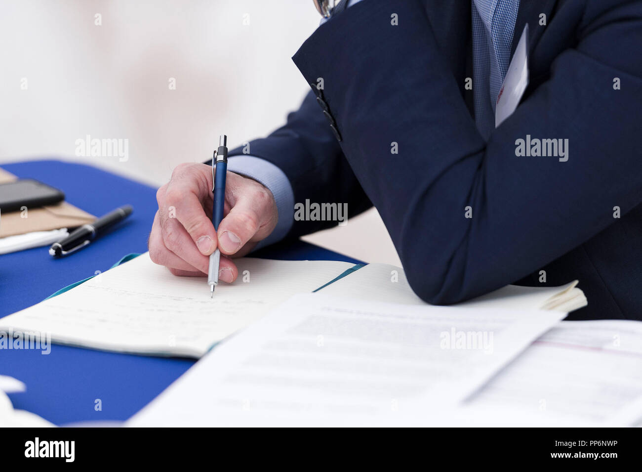 La prise de notes sur une pice de feuille avec un stylo pendant une réunion d'affaires Banque D'Images
