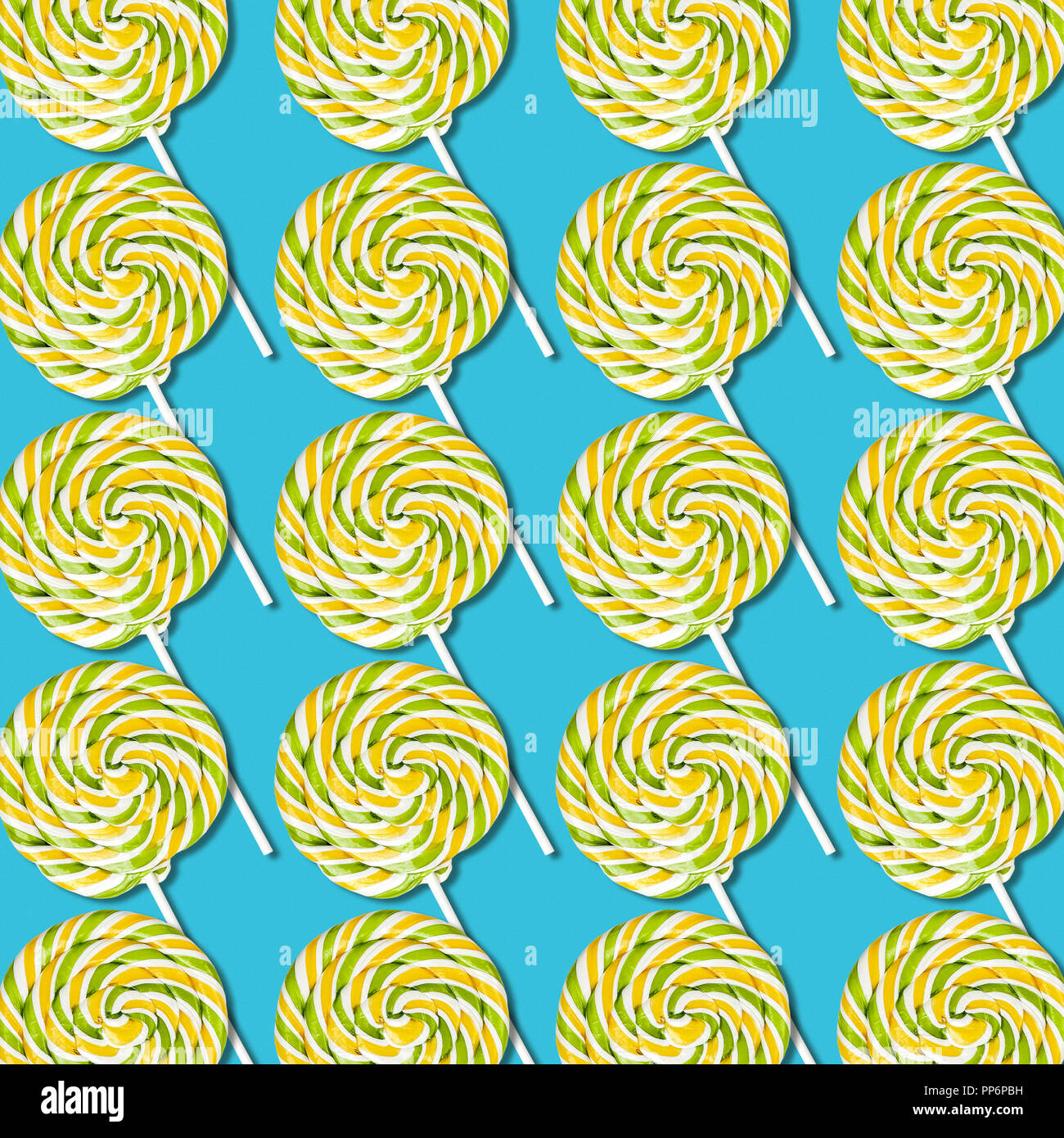 Bonbons sucette symétrique arrangement sur fond bleu turquoise, la texture des aliments sucrés colorés Banque D'Images