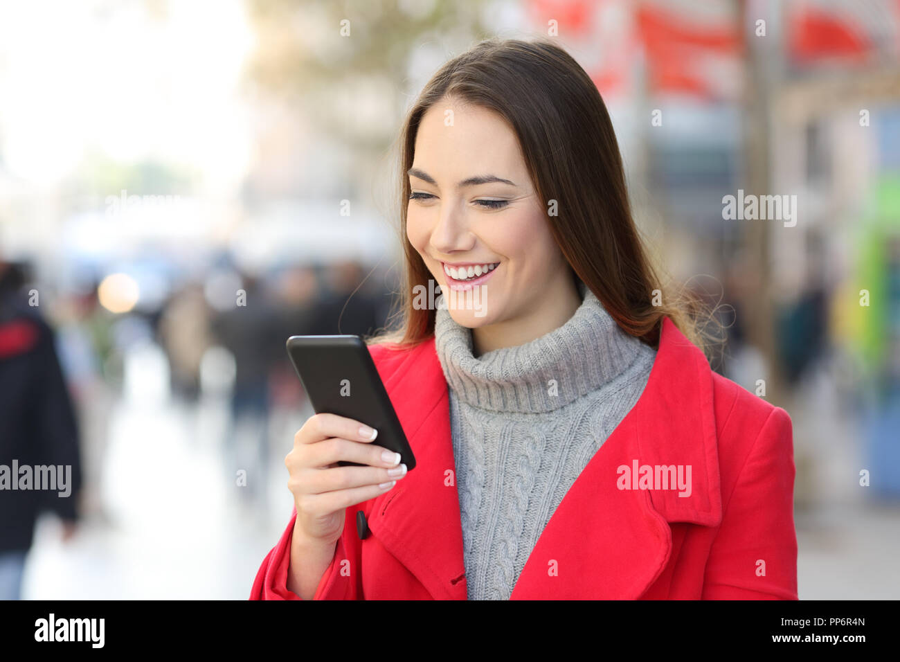 Happy woman in red phone messages sur la rue en hiver Banque D'Images