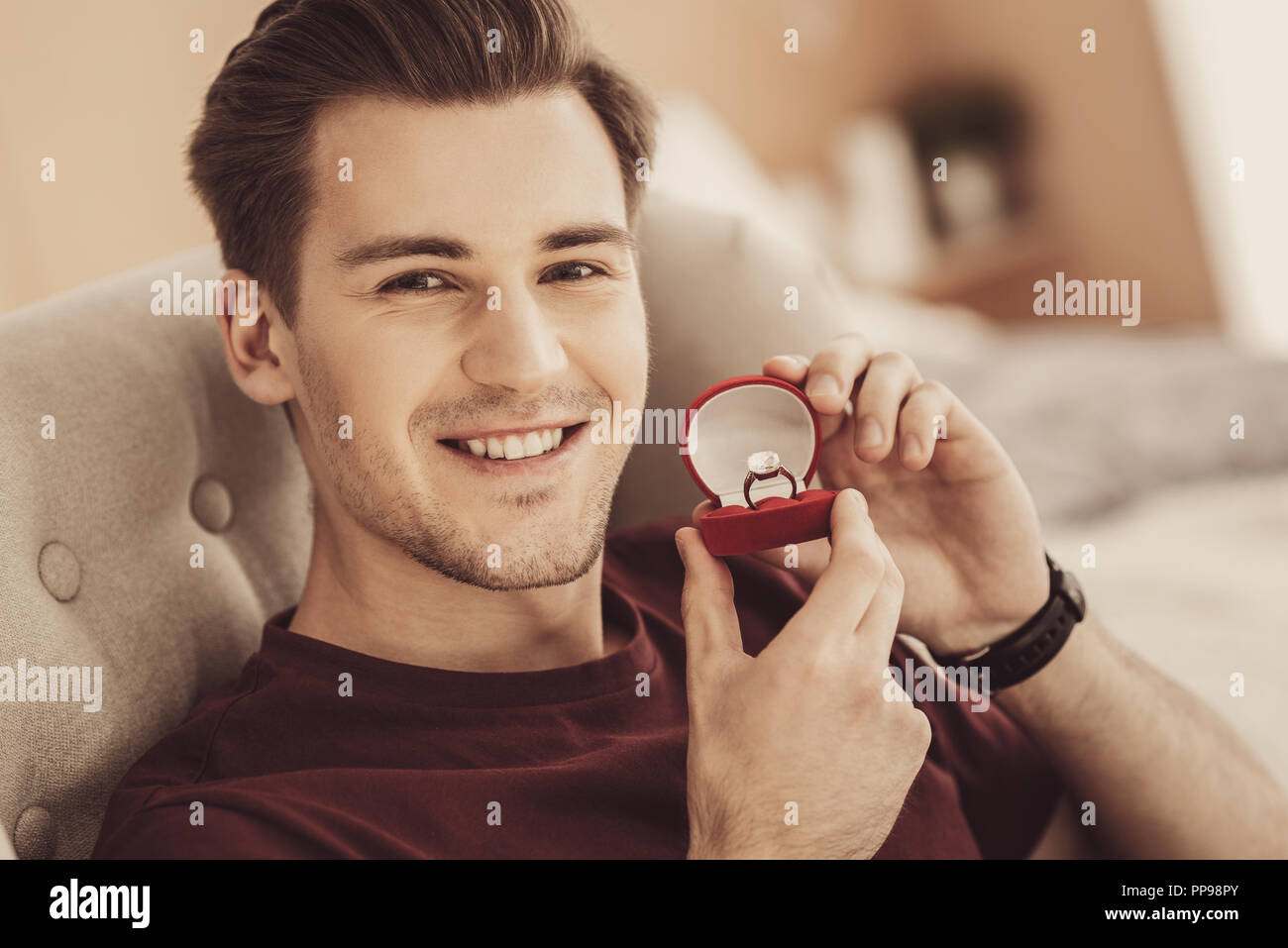 Transmission de dark-haired young man smiling tout en sentant l'excitation Banque D'Images