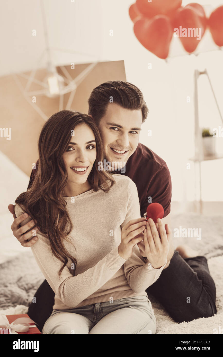 Futur mari souriant tout en serrant ses belles transmission d'amie Banque D'Images