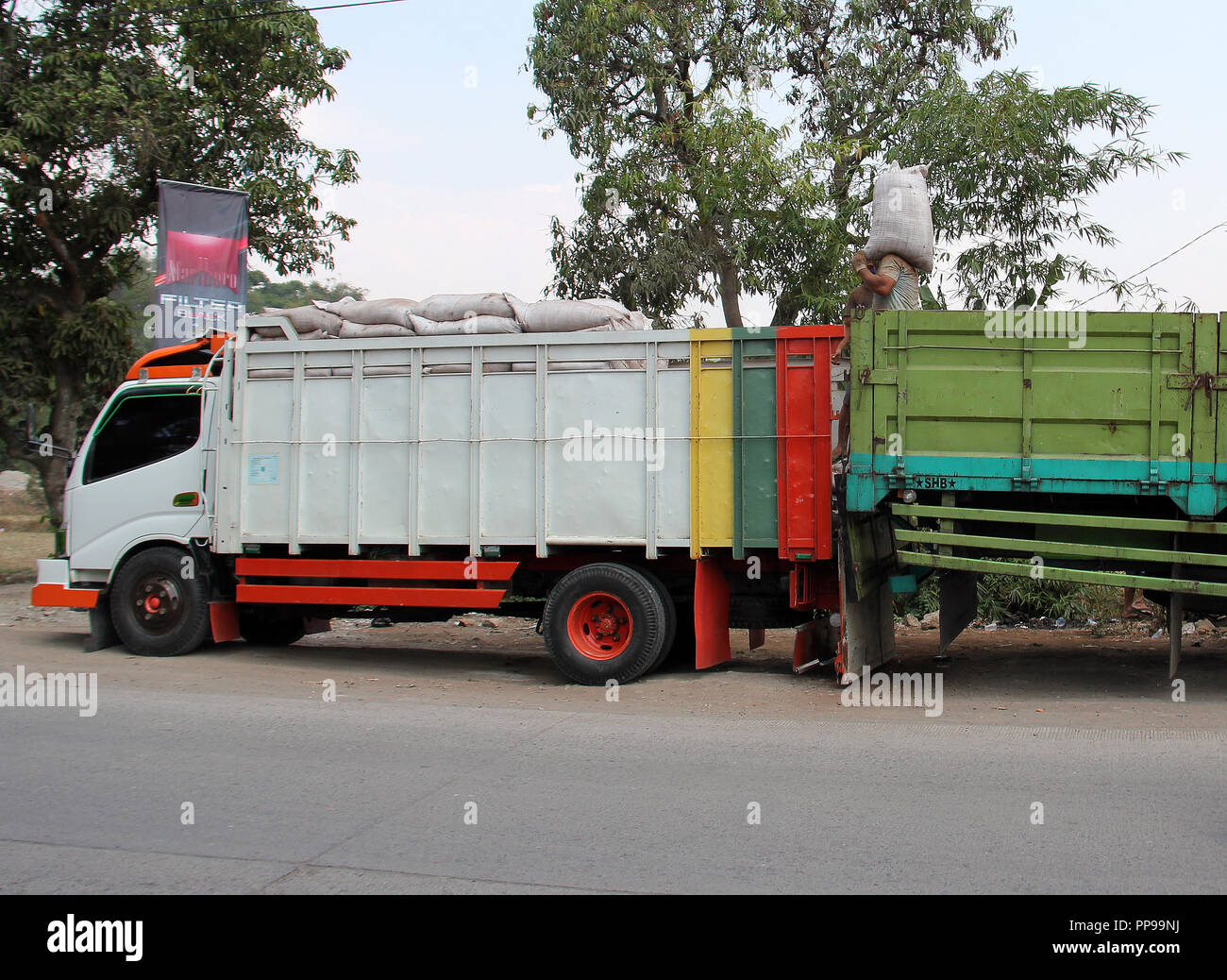 Les travailleurs du fret provenant de camions pour d'autres camions à Bandung, Indonésie, Asie du sud-est. Banque D'Images