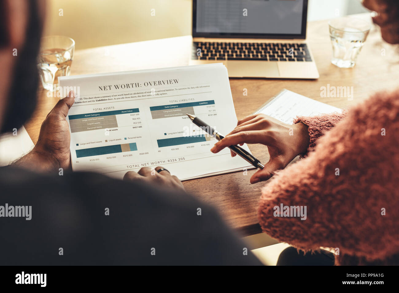 Les collègues assis à un bureau avec ordinateur portable et documents d'affaires. Businesswoman faisant une analyse de travailler avec un collègue. Banque D'Images