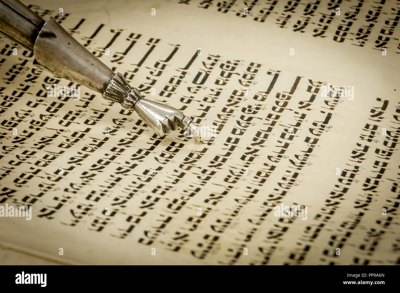 Pointeur de la Torah avec une main à la fin d'un doigt prolongé pour aider à lire le texte de l'Ecriture sainte de la Torah écrite en hébreu ancien. Méguila Banque D'Images